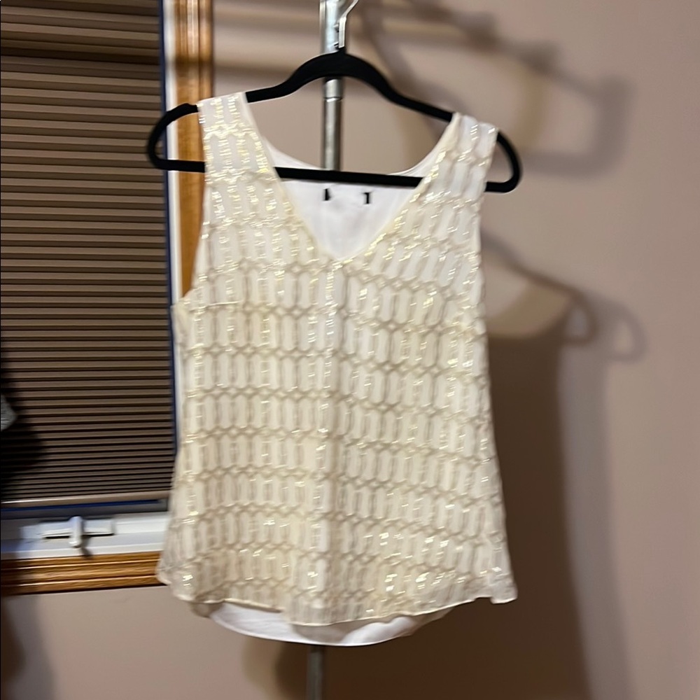 Delicate crème colored sleeveless blouse.  It’s great under a blazer